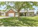 Single-story home featuring a brick accent, well-kept lawn, and mature tree shading the front at 6102 Boulder Dr, Anderson, IN 46013