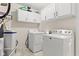 Functional laundry room with white cabinets and modern appliances including a washer and dryer at 6102 Boulder Dr, Anderson, IN 46013