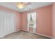 Cozy bedroom with neutral carpet, closet, and pink walls at 6928 Shoals Way, Indianapolis, IN 46237