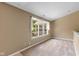 This bedroom has tan carpet and a window looking out to the backyard at 6928 Shoals Way, Indianapolis, IN 46237