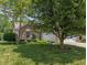 Charming home with brick facade, mature trees, and a well-maintained lawn at 6928 Shoals Way, Indianapolis, IN 46237