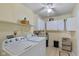 Bright laundry room features white washer and dryer, storage cabinets, and tile flooring at 6928 Shoals Way, Indianapolis, IN 46237