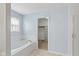 Soaking tub with a window, leading to a walk-in closet at 6928 Shoals Way, Indianapolis, IN 46237