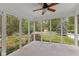 Relaxing screened porch with ceiling fan offers views of the lush backyard and playhouse at 6928 Shoals Way, Indianapolis, IN 46237