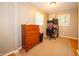 Neutral bedroom with wood dresser, writing desk, and a large window offering bright natural light at 7224 N Tuxedo St, Indianapolis, IN 46240