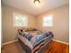 This cozy bedroom features natural light, hardwood floors, and bright, comfortable bedding at 7224 N Tuxedo St, Indianapolis, IN 46240