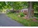 Charming brick home featuring mature trees and a well-manicured lawn and landscape at 7224 N Tuxedo St, Indianapolis, IN 46240