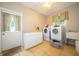 Well-equipped laundry room features a washer, dryer, utility sink, and ample storage space at 7224 N Tuxedo St, Indianapolis, IN 46240