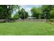 The huge backyard is enclosed with a wooden fence and has a lush lawn and mature trees at 7326 Lowe Dr, Lawrence, IN 46226