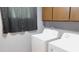 The laundry room features a washer and dryer next to cabinets and a window at 7326 Lowe Dr, Lawrence, IN 46226