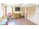 View of the living room with hardwood floors, TV, console, and exercise equipment at 7326 Lowe Dr, Lawrence, IN 46226