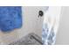 This is a bathroom shower with a shower curtain and blue towel at 7326 Lowe Dr, Lawrence, IN 46226