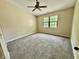 Bright bedroom with neutral walls and carpet, featuring a ceiling fan and window at 7450 Cobblestone W Dr, Indianapolis, IN 46236