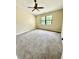Inviting bedroom features neutral walls, large window, ceiling fan, and plush carpeting for warmth at 7450 Cobblestone W Dr, Indianapolis, IN 46236