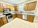 Bright kitchen featuring stainless appliances, wood cabinets, granite countertops and tile flooring at 7450 Cobblestone W Dr, Indianapolis, IN 46236