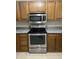 Kitchen featuring stainless oven and microwave with tile flooring and wood cabinets at 7450 Cobblestone W Dr, Indianapolis, IN 46236