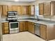 Well-equipped kitchen featuring stainless steel appliances, oak cabinetry, and granite countertops at 7450 Cobblestone W Dr, Indianapolis, IN 46236