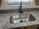 Close up on kitchen sink with granite countertops and grey tiled backsplash at 7450 Cobblestone W Dr, Indianapolis, IN 46236