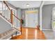 Inviting foyer with gleaming hardwood floors, staircase, and a charming bench at 7830 Cross Creek, Avon, IN 46123