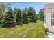 Well-maintained backyard showcases a manicured lawn and mature evergreens at 882 Lincoln Park W Dr, Greenwood, IN 46142