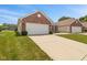 A view of a single-story home with an attached two-car garage and a driveway at 882 Lincoln Park W Dr, Greenwood, IN 46142