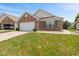 Charming one-story brick home featuring an attached two-car garage and a well-manicured lawn at 882 Lincoln Park W Dr, Greenwood, IN 46142