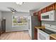 A kitchen featuring laminate flooring, gray walls, wooden cabinets, stainless steel, and white appliances at 882 Lincoln Park W Dr, Greenwood, IN 46142