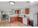 A view of a kitchen featuring laminate flooring, gray walls, wooden cabinets, and white appliances at 882 Lincoln Park W Dr, Greenwood, IN 46142