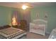 Bright, quaint bedroom features warm natural light, fan, bed, crib, and sitting area at 10166 Ranford Blvd, Fishers, IN 46040