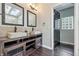 Bathroom featuring double vanity with stone sinks, modern fixtures, hardwood floors, and multiple mirrors at 1066 N Dogwood Way, Greenfield, IN 46140