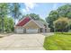Charming brick home features a three-car garage and a well-maintained front yard with mature trees at 1066 N Dogwood Way, Greenfield, IN 46140