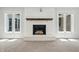Cozy fireplace with brick surround and a wood mantle, flanked by windows for natural light, creating a warm focal point at 1066 N Dogwood Way, Greenfield, IN 46140