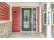 The front door is accented with decorative glass inserts and stylish black hardware and side light at 1066 N Dogwood Way, Greenfield, IN 46140