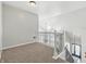 Upstairs hallway with wrought iron spindles, carpeted floor and view of front door at 1066 N Dogwood Way, Greenfield, IN 46140