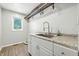Bright laundry room features stainless steel sink, granite countertops, and ample storage at 1066 N Dogwood Way, Greenfield, IN 46140