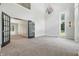 Spacious living room boasts vaulted ceilings, tall windows, and carpeted floors at 1066 N Dogwood Way, Greenfield, IN 46140