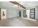 Spacious main bedroom featuring high ceilings with wooden beams, carpet, and ensuite bathroom with barn doors at 1066 N Dogwood Way, Greenfield, IN 46140