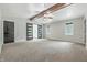 Spacious main bedroom featuring high ceilings with wooden beams, carpet, and ensuite bathroom with barn doors at 1066 N Dogwood Way, Greenfield, IN 46140