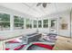 Cozy sunroom with wood floors, many windows and a built-in gas fire pit at 1066 N Dogwood Way, Greenfield, IN 46140