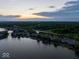 Picturesque aerial view of lakeside homes along a tree-lined shore, enhanced by a colorful sunset at 11137 Peppermill Ln, Fishers, IN 46037
