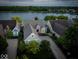 Aerial view of a charming home with manicured lawns, complemented by a serene lake backdrop at 11137 Peppermill Ln, Fishers, IN 46037