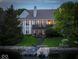 Back view of a luxurious lake house with a boat dock, lush green lawn, and mature trees at 11137 Peppermill Ln, Fishers, IN 46037
