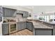 Basement bar with stylish gray cabinets, marble counters, wine fridge, and open layout at 11137 Peppermill Ln, Fishers, IN 46037