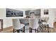 Basement bar featuring a wet bar with gray cabinets, marble countertops, and three barstools at 11137 Peppermill Ln, Fishers, IN 46037