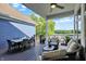 Covered deck with wicker furniture, dining table, and peaceful waterfront view at 11137 Peppermill Ln, Fishers, IN 46037