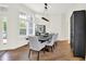 Bright dining room showcasing modern table, stylish chairs, and a unique black display cabinet, all enhanced by natural light at 11137 Peppermill Ln, Fishers, IN 46037