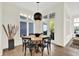 Bright dining area boasts natural light, wood floors, a modern light fixture, and views of the outdoors at 11137 Peppermill Ln, Fishers, IN 46037