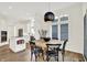 Open floor plan features kitchen and dining areas with black modern light fixture and wood floors at 11137 Peppermill Ln, Fishers, IN 46037