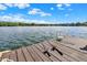 Wooden dock featuring fishing rods, perfect for angling on a clear day with picturesque lake views at 11137 Peppermill Ln, Fishers, IN 46037