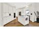 Spacious kitchen featuring white cabinets, stainless steel appliances, a center island, and hardwood floors at 11137 Peppermill Ln, Fishers, IN 46037